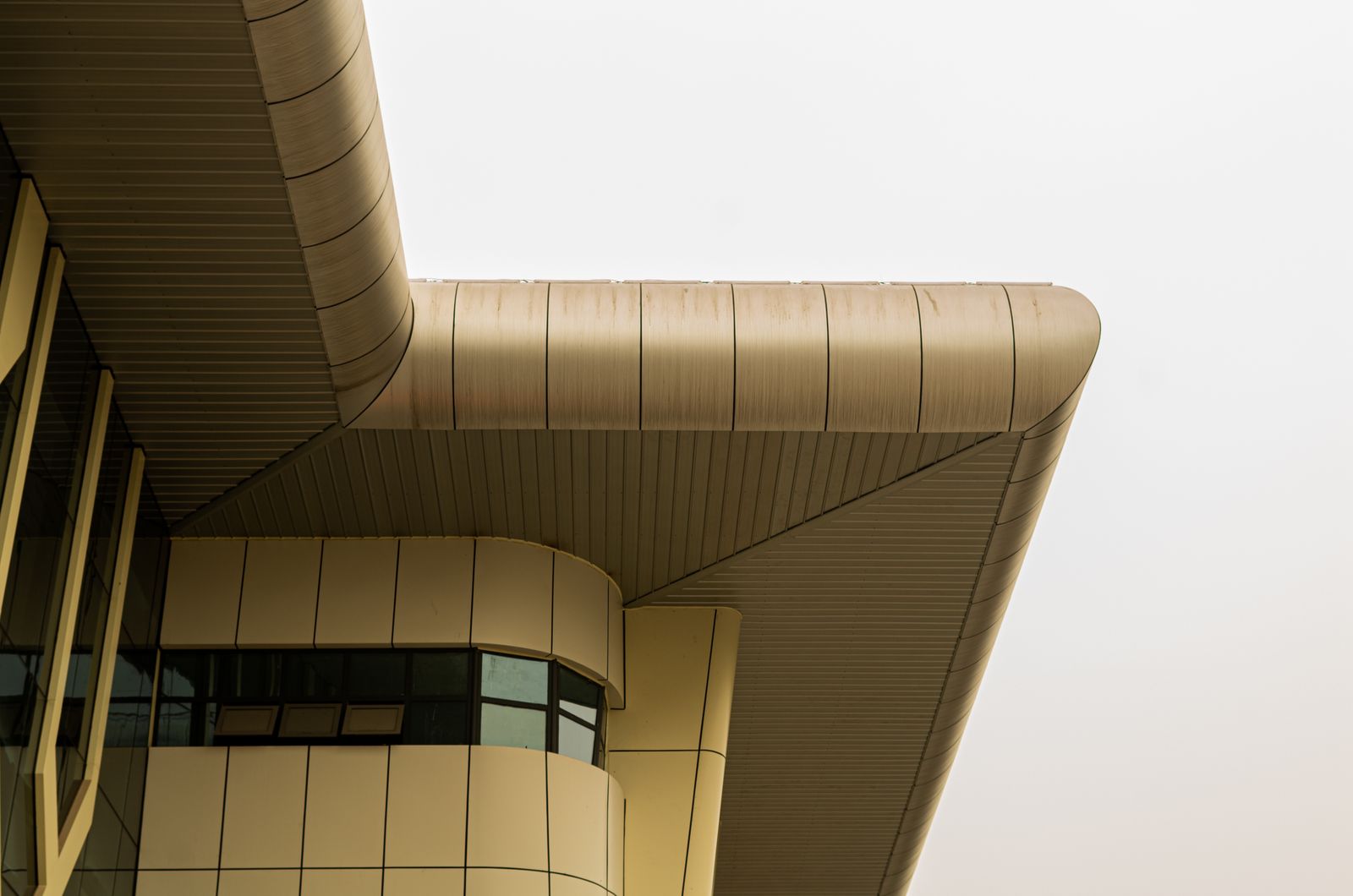 Curved metallic architectural facade cladding on a modern building