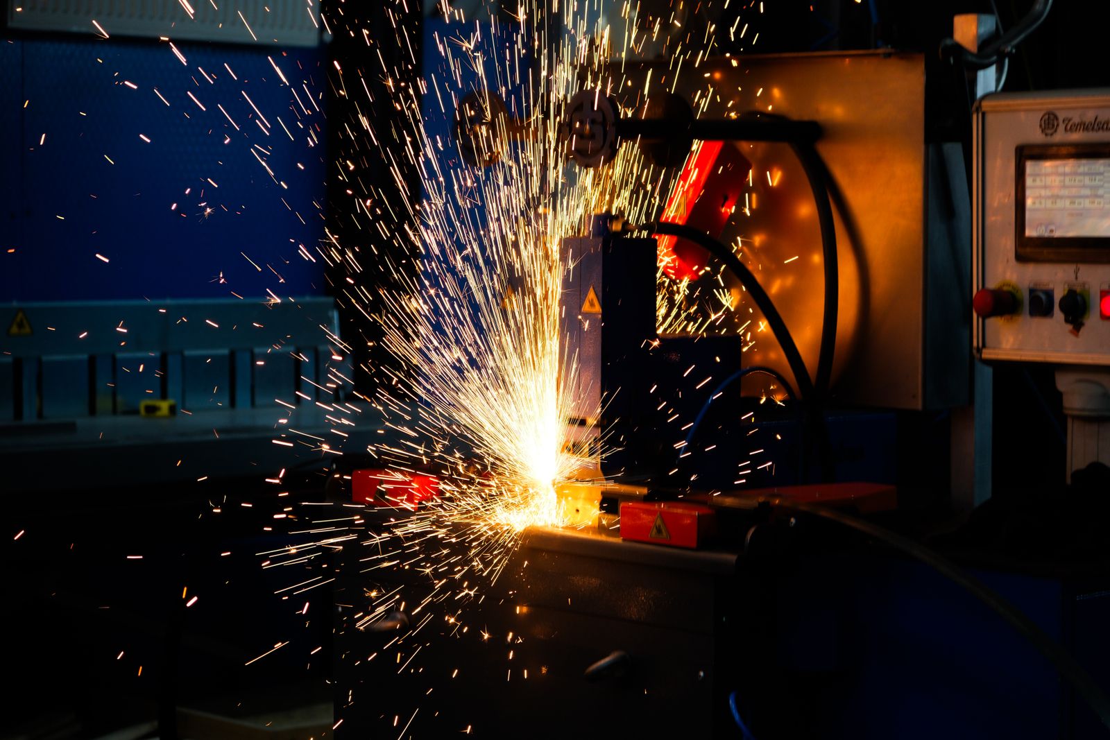 Precision metal fabrication with welding sparks in an industrial workshop